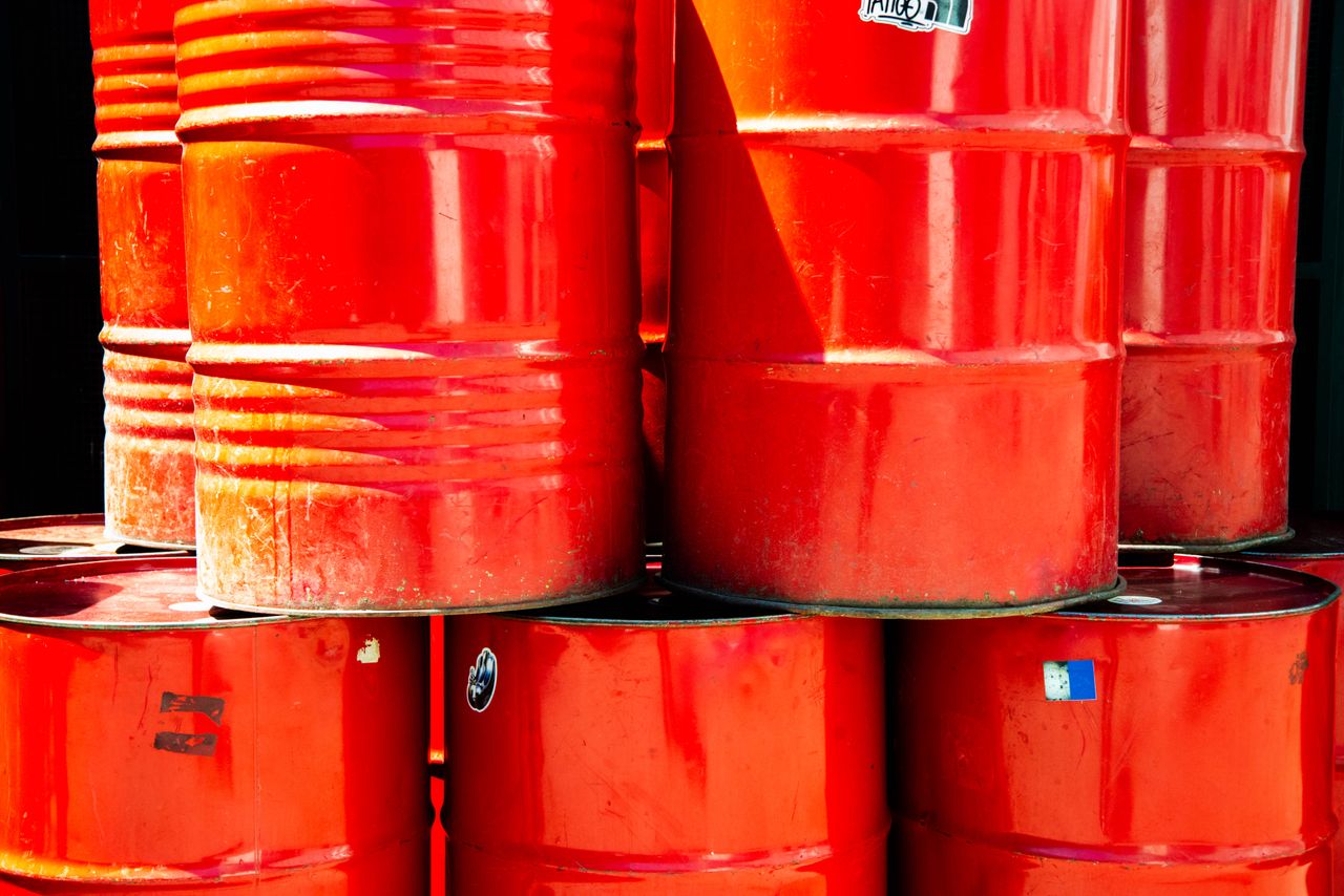 How to Choose the Right Chemical Supplier for Your Business Bright red industrial oil barrels stacked outdoors in daylight, showcasing vivid color and industrial theme.